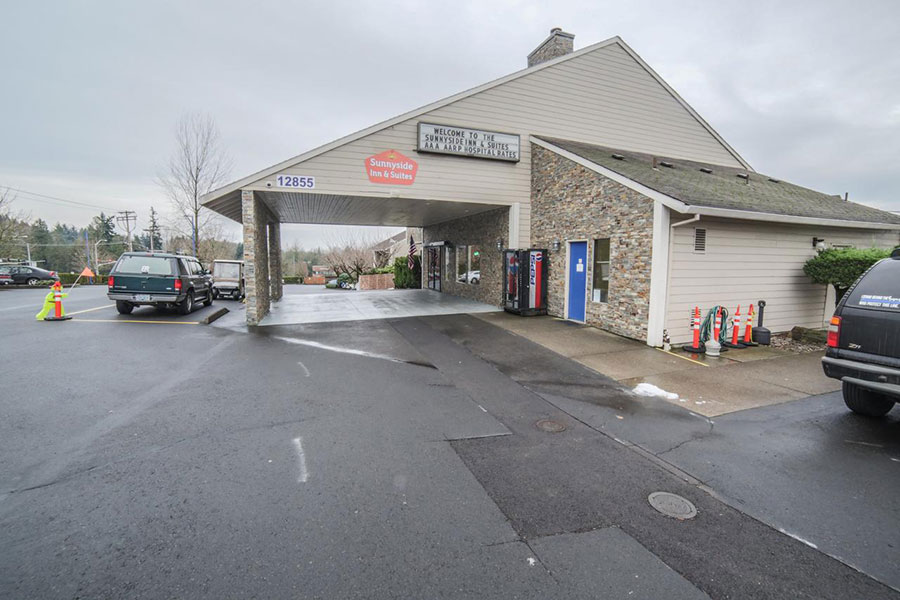 exterior building and partial parking lot view of Sunnyside Inn and Suites